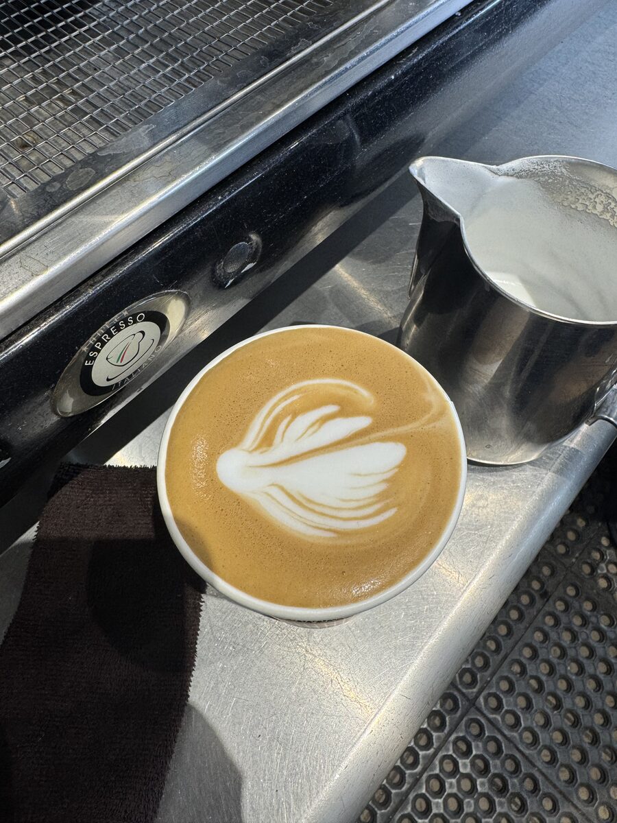 Winged rosetta in a ceramic cup next to the milk pitcher