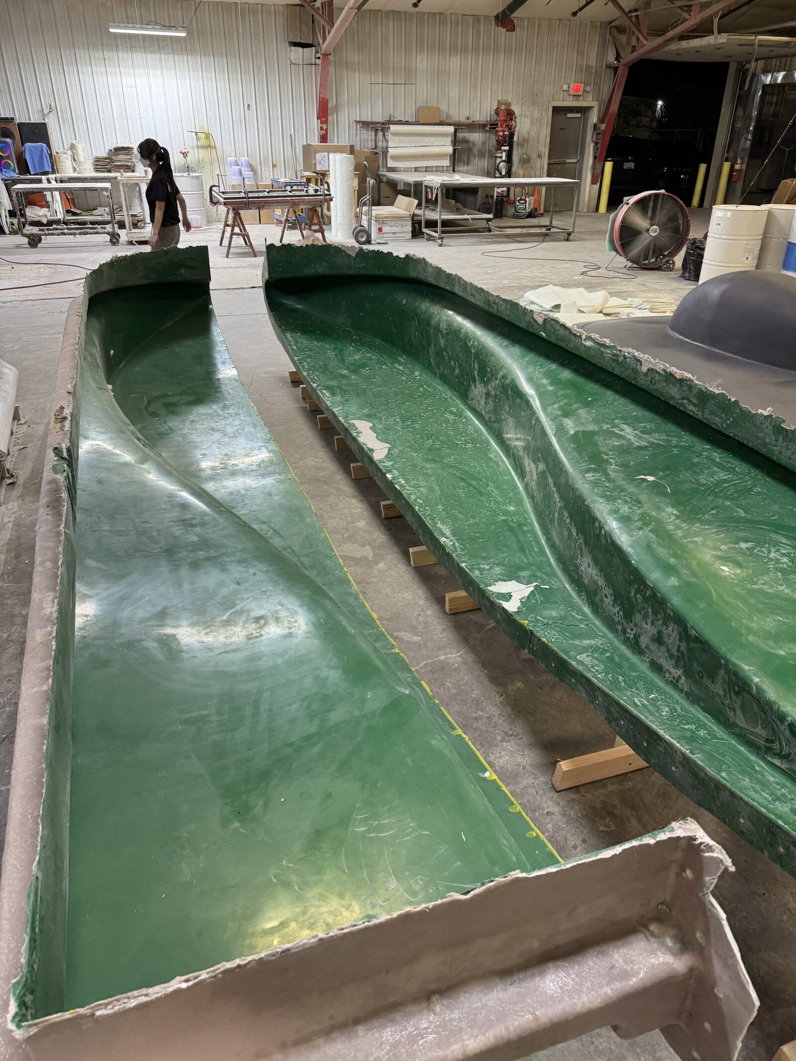 Two green fiberglass negative mold halves side by side