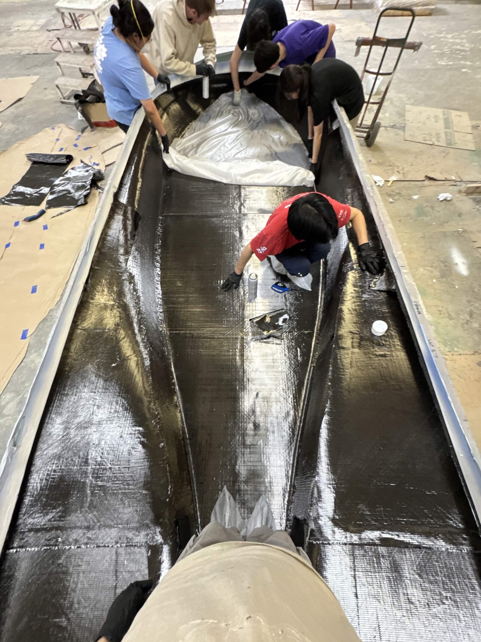 Team laying tri-axial carbon fiber inside the bottom shell mold