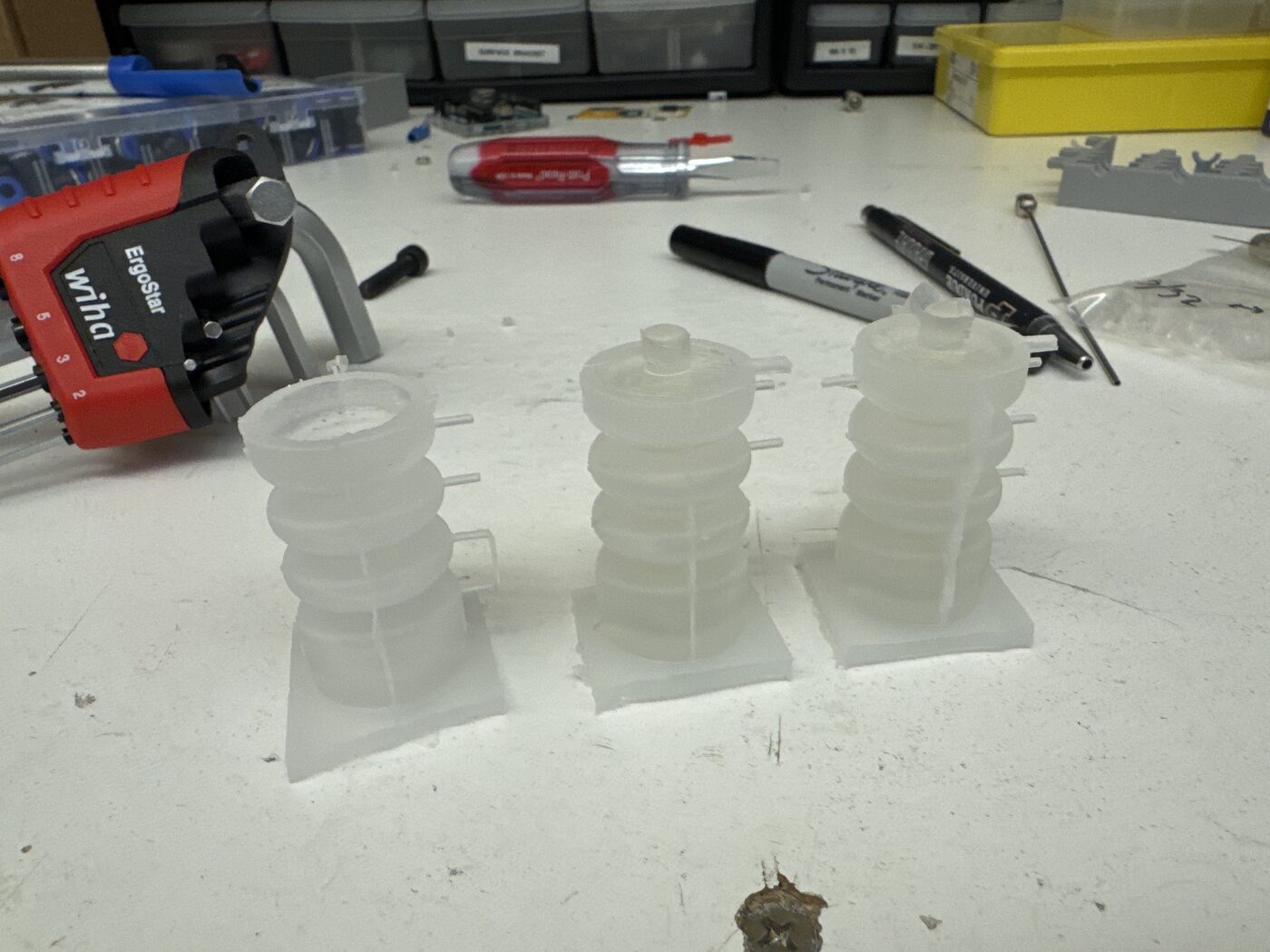 Three molded silicone bellows standing on their printed bases